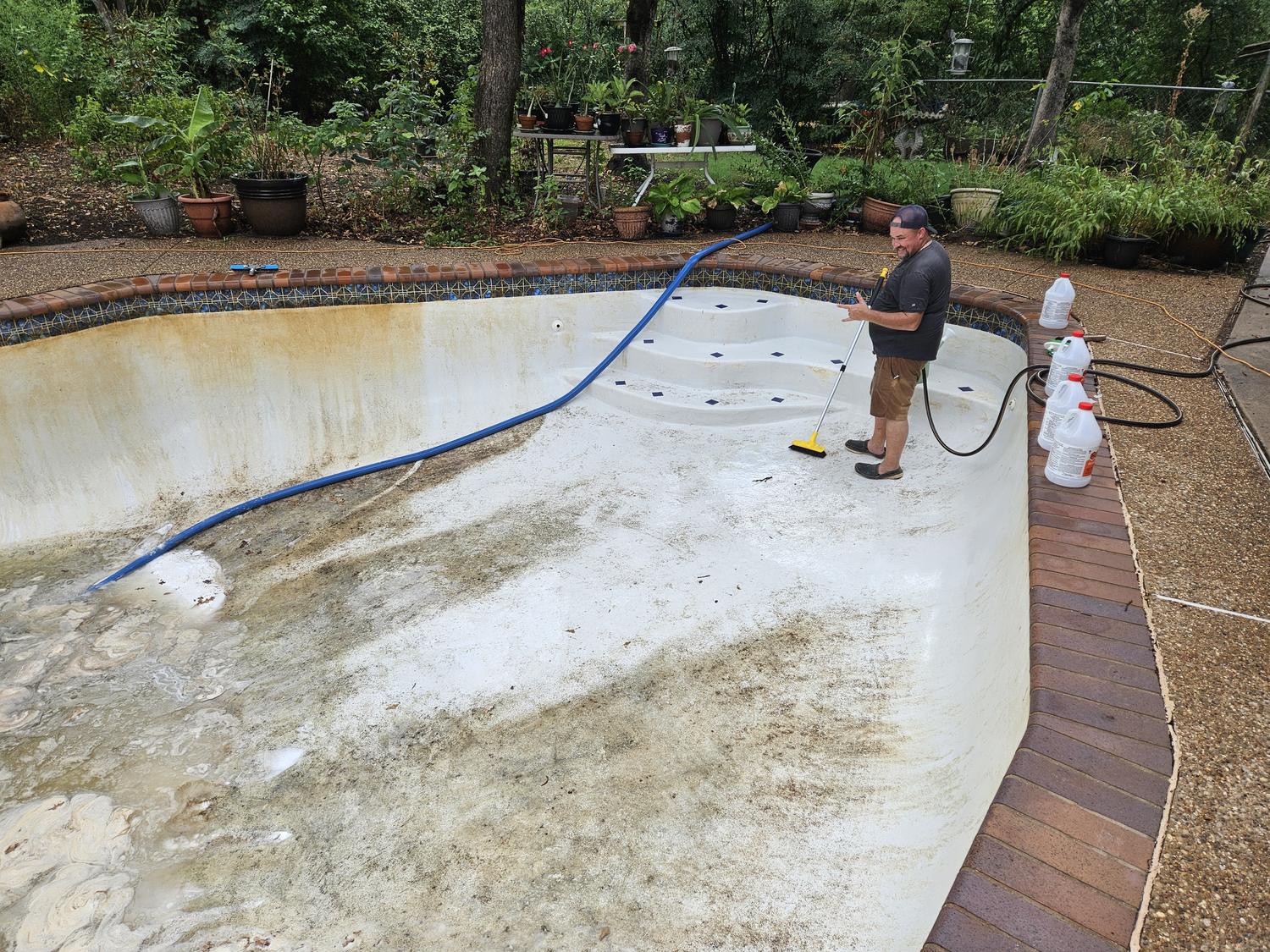 McEwan Pools washing the plaster of a drained pool in Mansfield, half the floor already cleaned