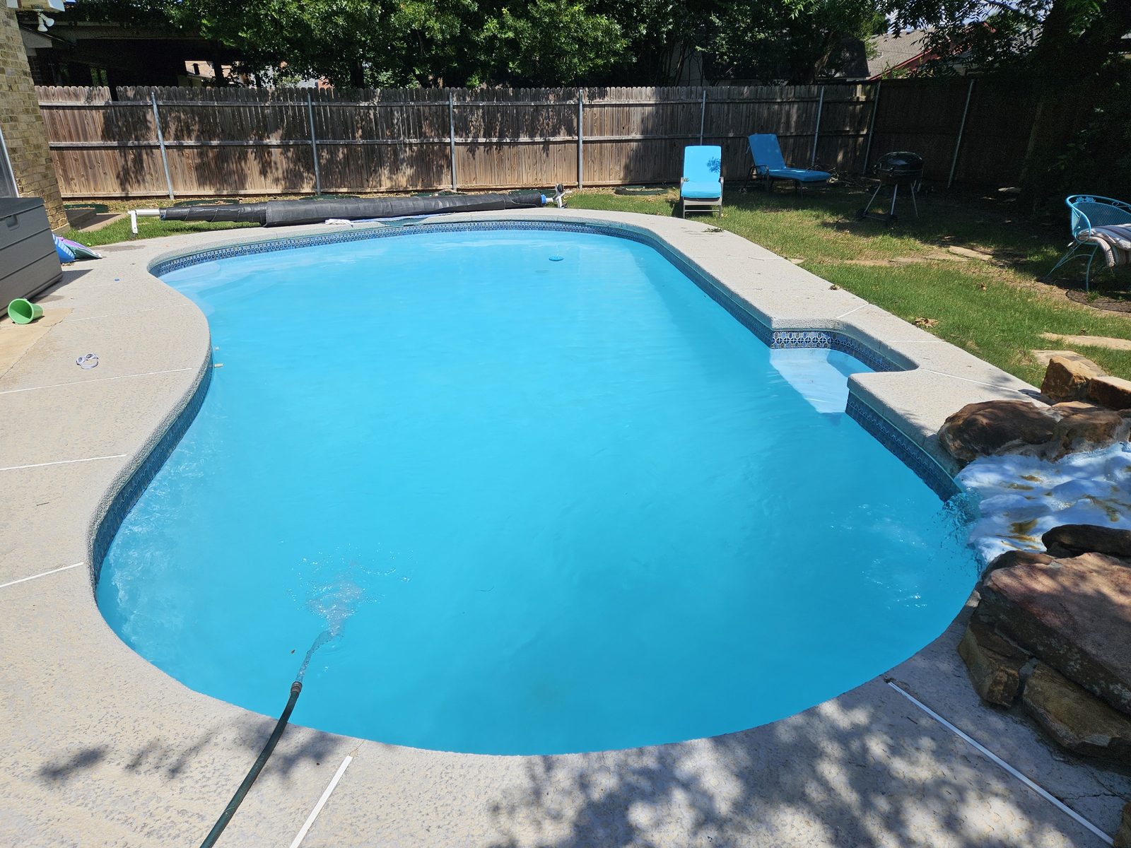 Freeform pool with a rock waterfall and clear water